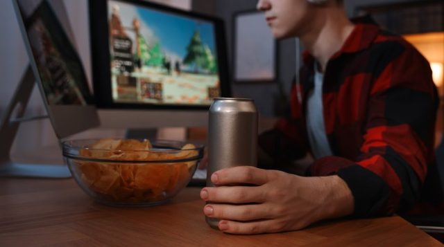 young man at desk with energy drink