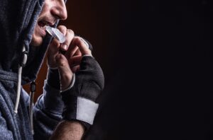 Athlete wearing a sports mouthguard while preparing for training, highlighting the importance of custom-fitted guards for oral protection during high-impact sports.