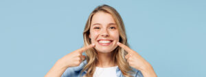 young woman pointing at her smile
